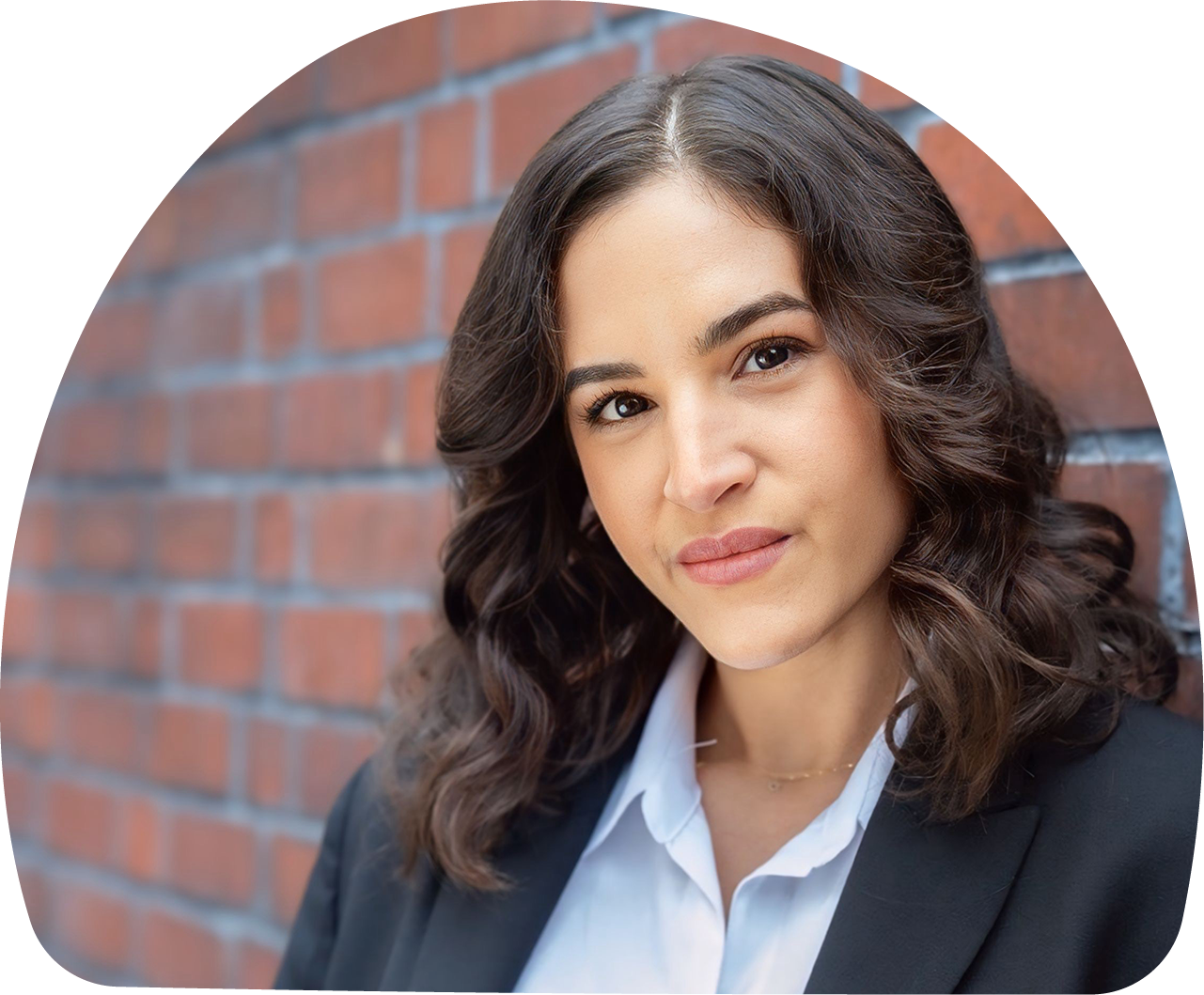 Close-up of MOMent founder Shani Hersonski standing in front of a red brick wall