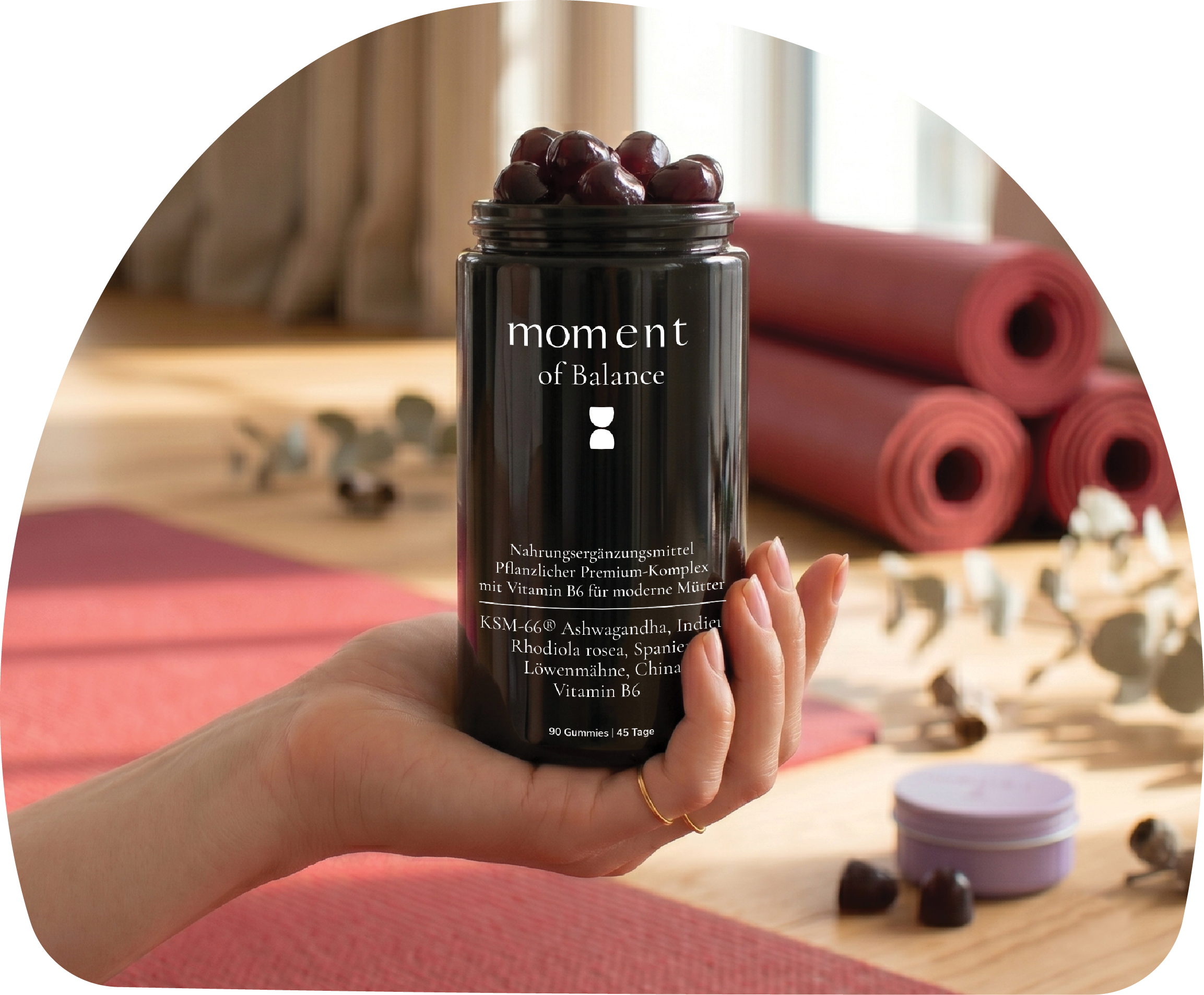 MOMent of Balance supplement jar. Wellness shoot, hand holding the jar, with yoga studio background.